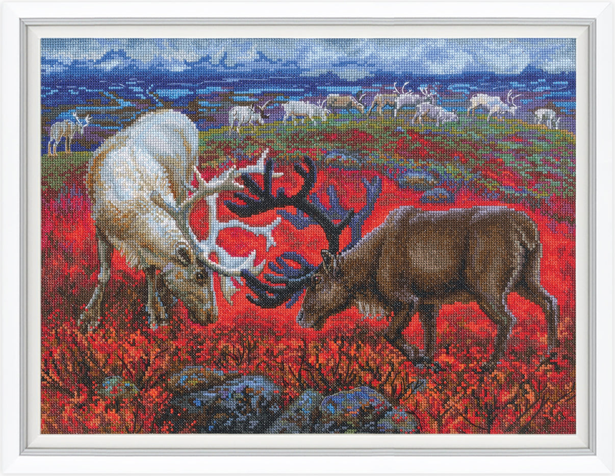 Cross-stitched scene of two reindeer in a field with a scenic background