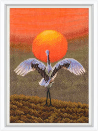 Cross-stitched artwork of a crane with an orange sunset in the background