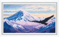 Cross-stitched artwork of a mountain landscape with a bird flying over it.