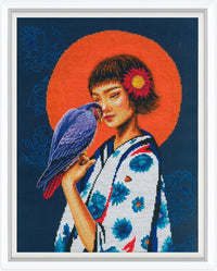 Cross-stitched artwork of a woman with a parrot and floral design